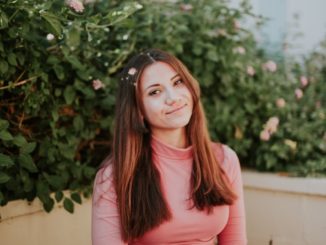 woman sitting near pink flowers at daytime